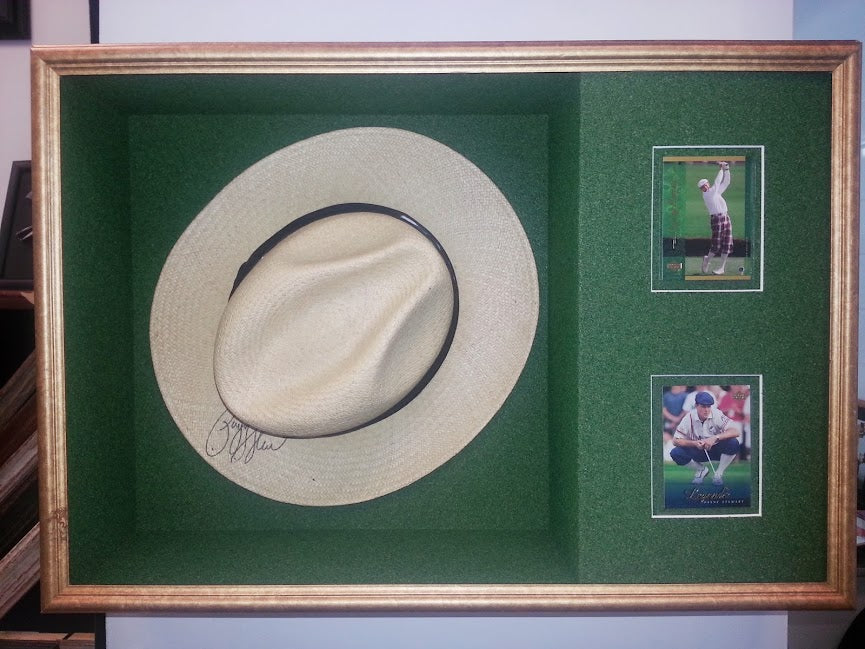 Payne Stewart signed golf hat framed in a custom shadowbox with green 'turf' matting and sports trading cards by Framing & Display.